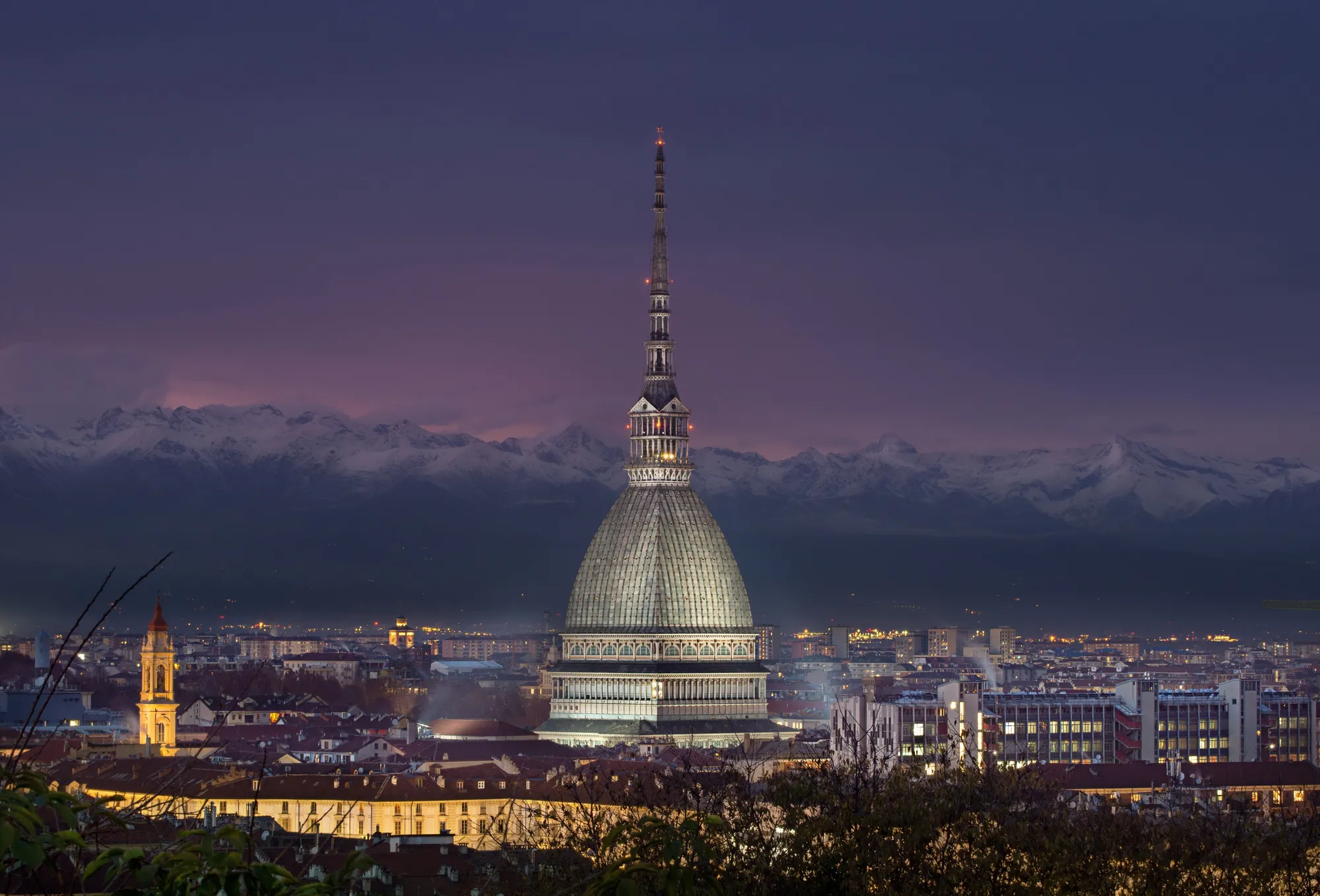 Turin at dusk, the Mole Antonelliana lit up against the Alps